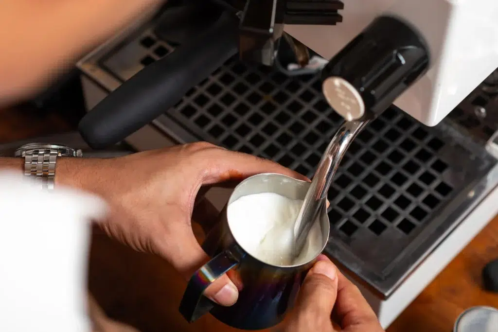 Barista steaming milk with a coffee machine